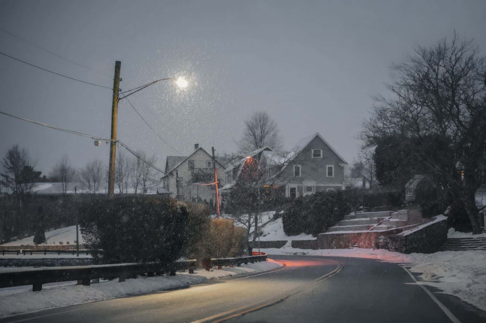 Residential street after snowfall, with bare trees and overhead lines